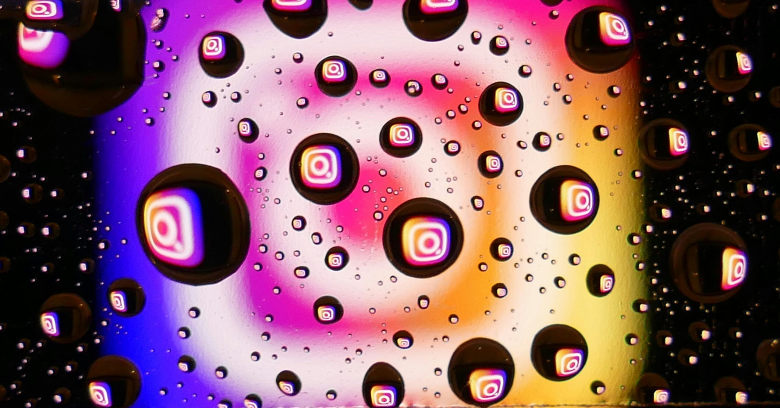 Vibrant water droplets on a colorful background reflecting Instagram logos, showcasing abstract digital creativity.